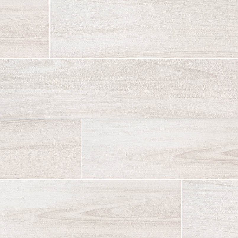 MSIs 10 in. x 40 in. Braxton Blanco Porcelain Floor & Wall Tile features large, light gray wood-patterned planks with a staggered design, highlighting natural wood grain textures. These tiles offer high durability and elegant longevity for any space.