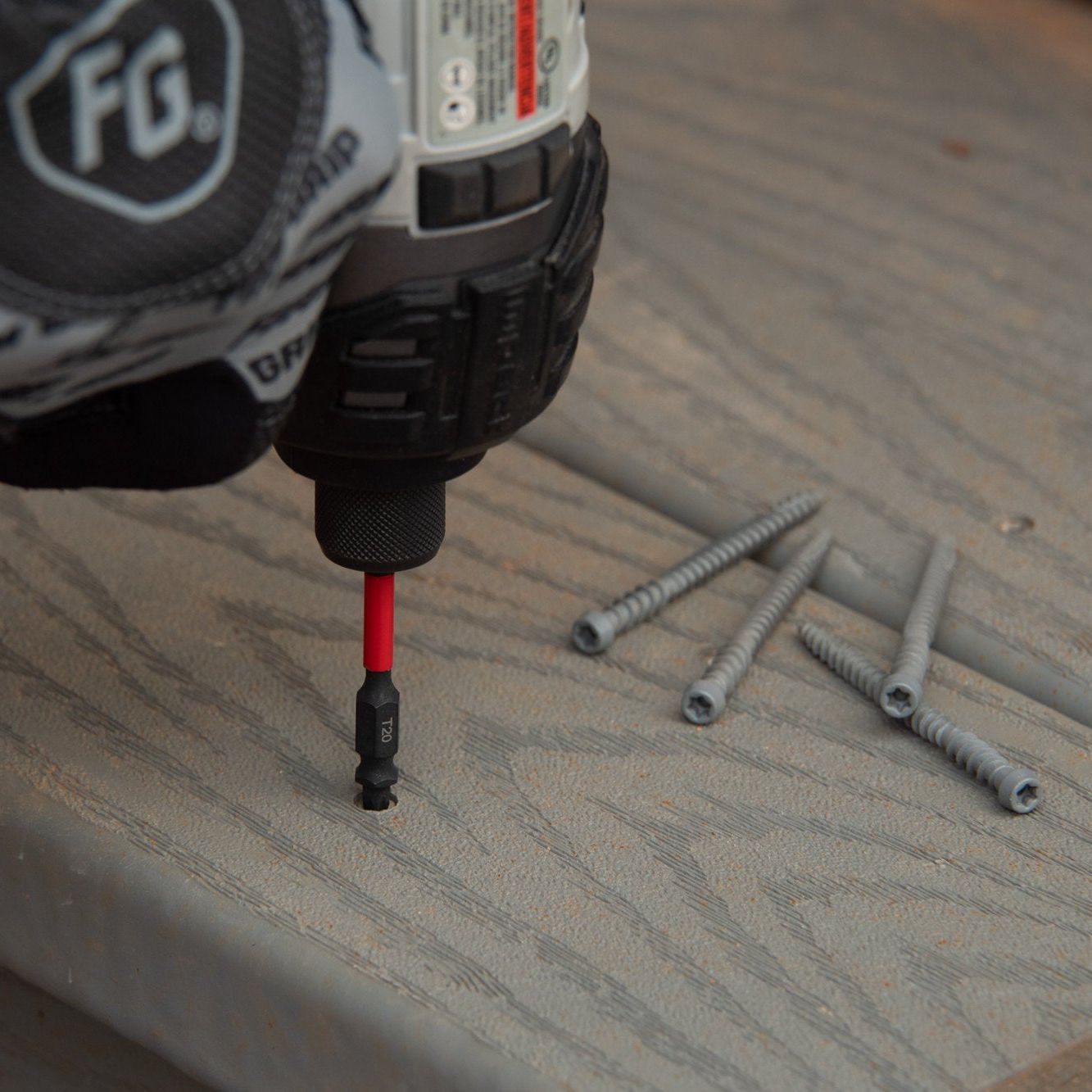 A gloved hand expertly uses a Diablo DIABLO DDEPHV25-S3 2-3/8 in. Double-Ended Phillips Drive Bit from the 3-piece set to drive a screw into wood. Several screws lie scattered nearby, ready for use. The MaxTorque Zone ensures precision and control.