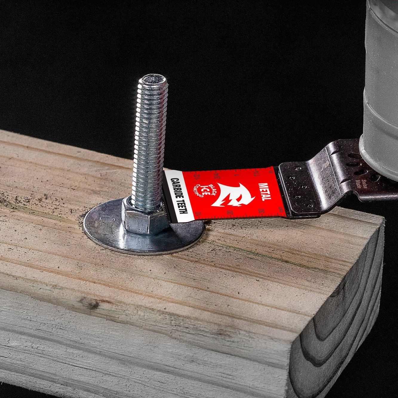 Extreme durability is showcased as a DIABLO DOU125CF 1-1/4 in. AMPED™ Steel Demon™ Universal Fit Carbide Teeth Oscillating Blade for Metal tightens a bolt into wood, with a red Metric marked tape beneath on a black backdrop.