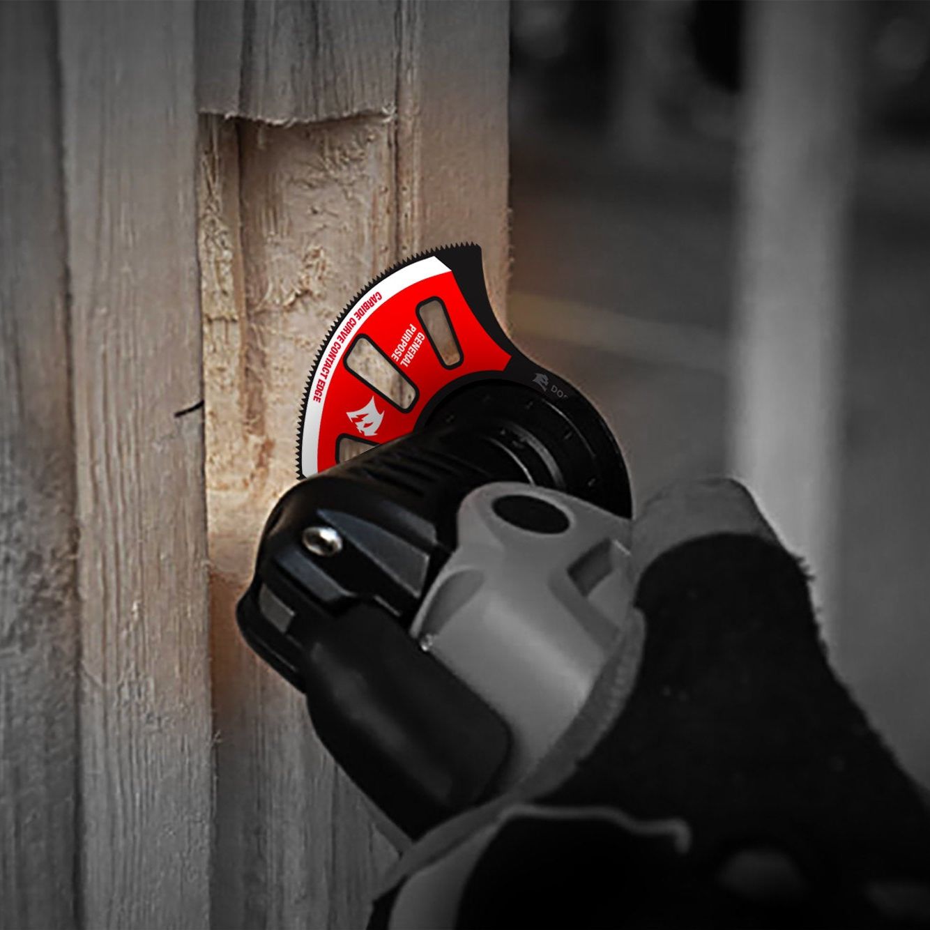 A gloved hand holds a DIABLO DOU275RCGP AMPED™ Demo Demon™ blade, featuring TiCo Hi-Density carbide teeth. Its red circular blade cuts into wood, with a blurred background highlighting the precision and intricate details of this general-purpose oscillating tool.