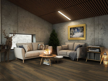 Modern cozy living room with concrete walls, MSI XL Cyrus Barrell Luxury Vinyl Planks flooring, beige sofas, a round coffee table with candles, Christmas tree, window, deer sculpture, record player, and a framed winter landscape painting.