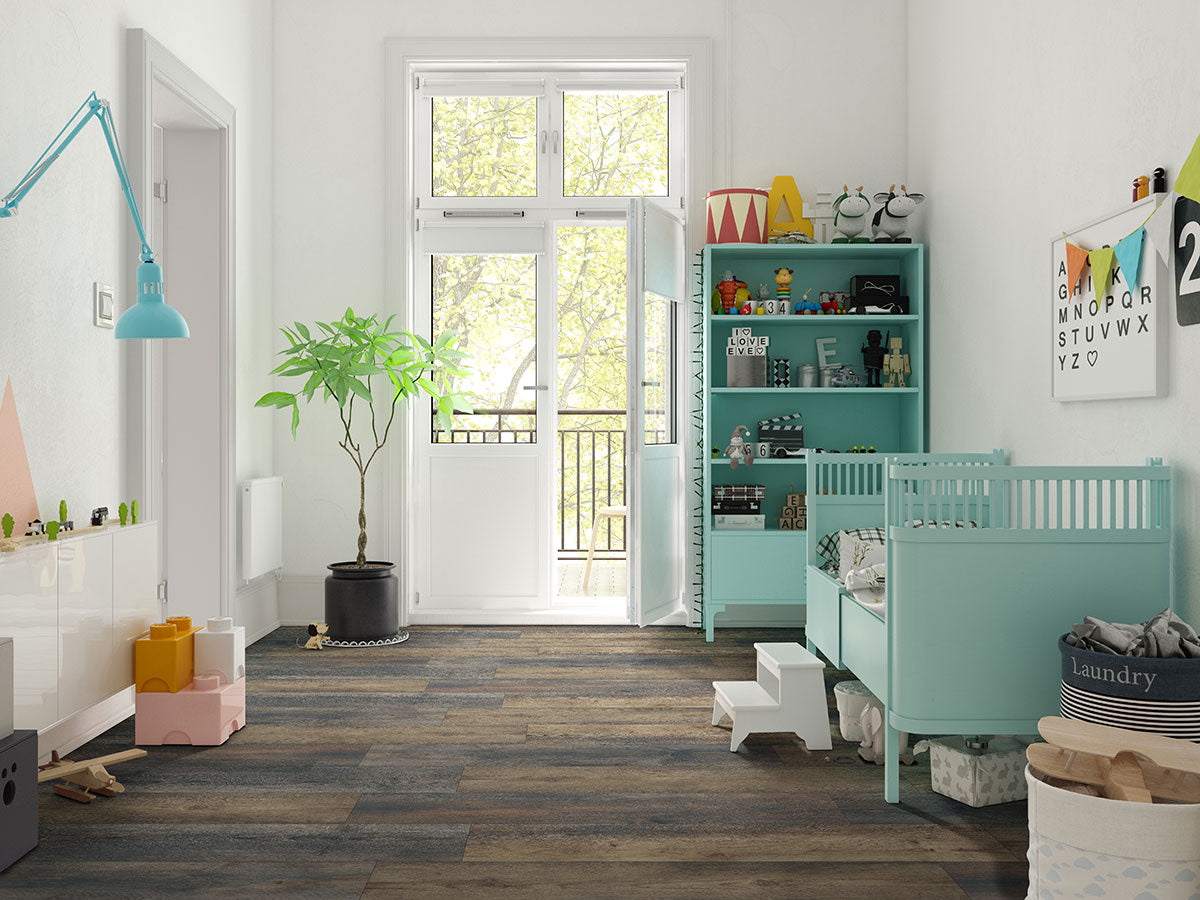 Bright, modern nursery with teal furniture, crib, shelving, potted plant, wall art, and toys. Large windows fill the room with light. MSI’s XL Cyrus Stable Luxury Vinyl Planks add stylish warmth and durability to the space.
