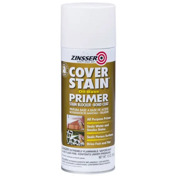 A 13 oz. can of Zinsser Cover Stain White Oil-Based Interior/Exterior Primer and Sealer Spray features a white cap and gold label with English and Spanish text, highlighting stain blocking and strong surface adhesion.
