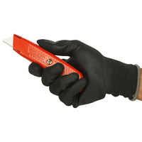 A hand in a black glove holds the STANLEY® Self-Retracting Safety Utility Knife by STANLEY, featuring a red handle and a partially extended blade.