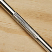 A close-up of the STANLEY Hobby Knife featuring a textured, crosshatched grip and replaceable blades, placed on a light wooden surface.