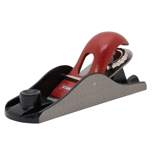 The STANLEY 6-5/8 IN ADJUSTABLE BLOCK PLANE, featuring a black base, silver sides, and a red handle and blade cover, is ideal for precision trimming and smoothing wood surfaces.