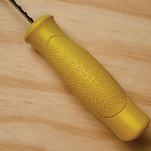 A STANLEY® Jab Saw, 6TPI with a yellow textured handle and black metal shaft rests on a light wood surface.