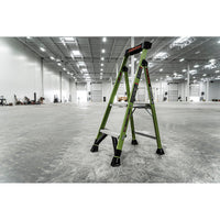A LITTLE GIANT 15394-001 MightyLite IA 4 ft. fiberglass stepladder, rated for 300 lbs., stands open in a brightly lit, spacious industrial warehouse with high ceilings.