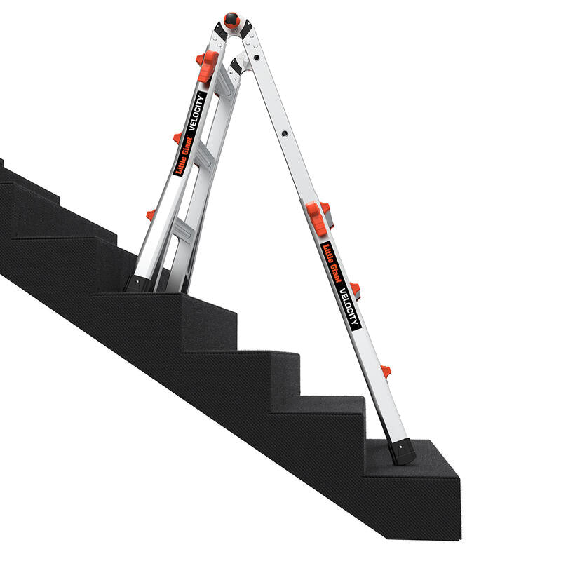 The LITTLE GIANT 15413-001 Velocity IA 3 ft. - 11 ft. Aluminum Articulated Extension Ladder from LITTLE GIANT is set up on a staircase, showing its stable and adjustable design for use on uneven surfaces.