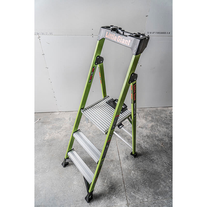 A LITTLE GIANT 15395-001 MightyLite IA 5 ft. fiberglass stepladder (300 lb. rating) stands open on a concrete floor in front of a partially finished drywall wall.