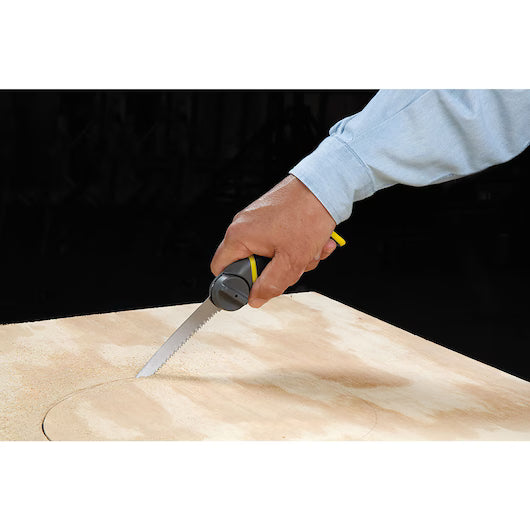 A person in a blue shirt uses the STANLEY 3-in-1 Multi-Purpose Saw to cut a circular shape into a sheet of plywood.