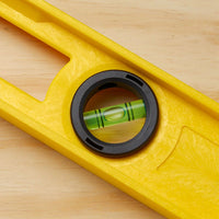 A close-up of the STANLEY 24 in High-Impact ABS Level on a light wooden surface, showing its centered bubble vial and highlighting this reliable leveling tool in a perfectly level position.