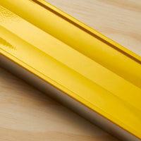 A close-up of the STANLEY® FATMAX® Aluminum Box Beam Level 1200mm lying on a light wooden surface, highlighting its smooth, reflective finish and precise edges—a professional-grade STANLEY construction tool.