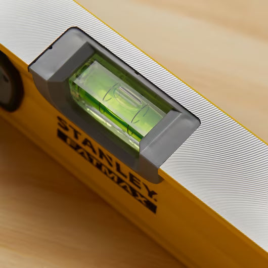 Close-up of the STANLEY® FATMAX® Aluminum Box Beam Level 1200mm by STANLEY on wood, its bubble centered—an ideal level for any professional construction tool kit.