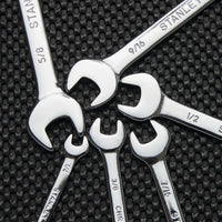 Six STANLEY COMBINATION WRENCH SET SAE (6 PC) tools, made from durable Chrome Vanadium Steel, are arranged in a circle on a textured black surface with sizes visible on each handle and heads facing inward.