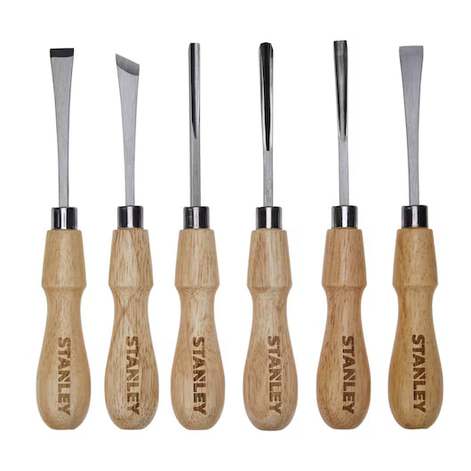 The STANLEY 6 PC WOOD CARVING TOOL SET features six wood-handled chisels and gouges with unique steel blades, arranged upright on a white background—perfect for detailed woodworking projects.
