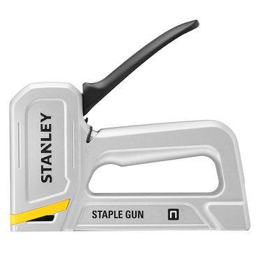 The STANLEY® Aluminium Staple Gun, a durable silver stapler with a black handle and yellow accent, is ideal for upholstery tasks.