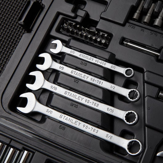 A close-up of a black STANLEY 1/4 IN & 3/8 IN DRIVE MECHANIC TOOL SET (145 PC) shows four combination wrenches and assorted socket set components and bits, all neatly arranged in their designated slots.