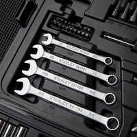A close-up of a black STANLEY 1/4 IN & 3/8 IN DRIVE MECHANIC TOOL SET (145 PC) shows four combination wrenches and assorted socket set components and bits, all neatly arranged in their designated slots.
