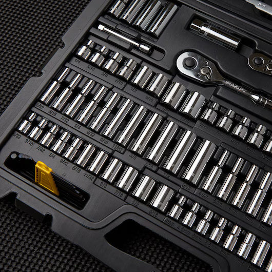 A close-up of the STANLEY 1/4 IN & 3/8 IN Drive Mechanic Tool Set (145 PC) in its black case, featuring assorted sockets, a ratchet, and hand tools—an essential for any automotive toolkit—displayed on a textured black surface.