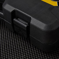 Close-up of a textured black plastic STANLEY 1/4 IN & 3/8 IN DRIVE MECHANIC TOOL SET (145 PC) case with a secure latch, resting on black carbon fiber; the top right shows the corner of its yellow label.