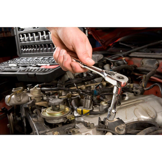 A hand uses a STANLEY MECHANIC TOOL SET (201 PC) ratchet wrench on a car engine, with the tool kit visible in the background.