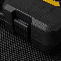 A close-up of a black, textured hard plastic case with a latch, likely containing a STANLEY MECHANIC TOOL SET (201 PC), resting on a black surface. A portion of a yellow label appears on the top right corner of the case.