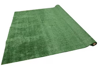 A TrafficMaster Emerald Green Precut Turf 6 ft. x 8 ft. Artificial Grass Rug is partially unrolled on a white background.