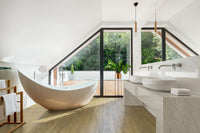 Modern bathroom with a sculptural tub, dual vessel sinks on marble, and bright decor. Features MSI Cyrus Brookline Luxury Vinyl Planks (23.77 SQFT/box), offering 100% waterproof, click-lock floating installation for effortless style.