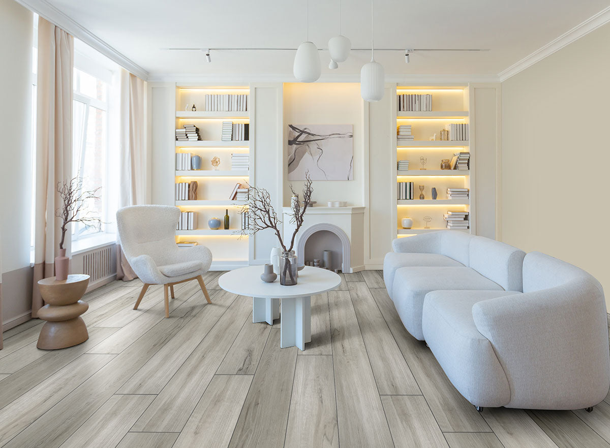 Modern living room with MSI XL Cyrus Dunite Oak Luxury Vinyl Planks (22.44 sq ft/box), featuring a CrystaLux™ wear layer, waterproof SPC core, white curved sofa, round coffee table, armchair, built-in shelves, and soft lighting.