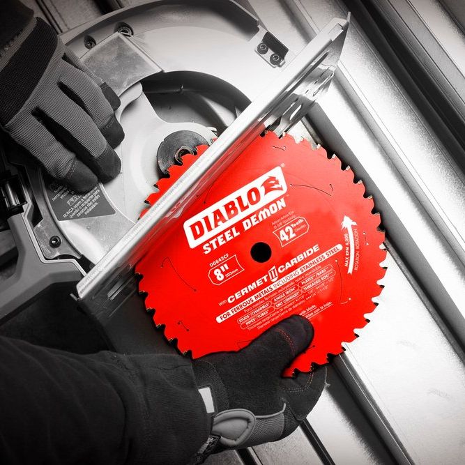 A gloved individual installs an 8-inch Diablo DIABLO D0842CF Steel Demon™ Cermet II saw blade with 42 teeth into a circular saw, designed for thick metal cutting. The image showcases the blades branding and details, ideal for slicing through stainless steel.