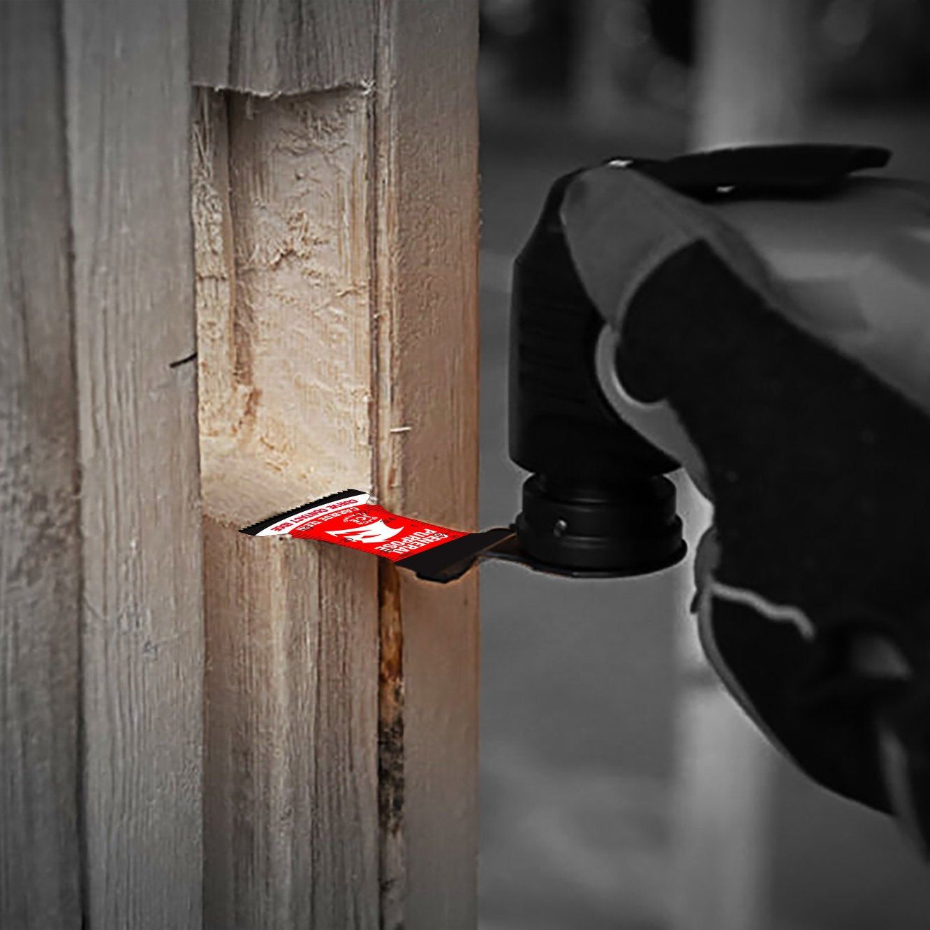 A close-up shows a gloved hand holding a power tool with Diablos DIABLO DOS125CGP3 1-1/4 in. AMPED™ Demo Demon™ Starlock Carbide Teeth Oscillating Blade cutting through wood. The red blade, featuring carbide teeth for durability, is in focus against a slightly blurred background.
