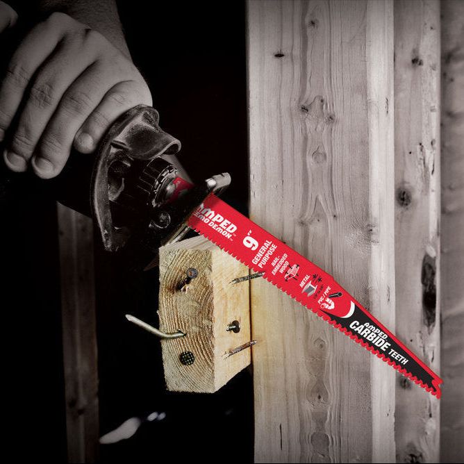 Close-up of a person using a DIABLO DS0609CGPA3 6 in. AMPED™ Demo Demon™ blade to cut through a wooden beam fixed with screws. The Black I.C.E. coated blade, showing detailed specifications, stands out in the dim background, highlighting its precision with every cut.