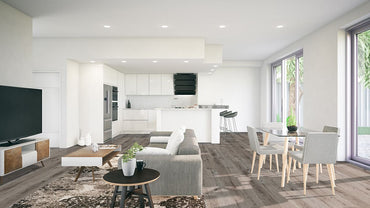 Modern open-plan living area with gray sofa, coffee table, TV, and dining table. The white kitchen features MSI Cyrus Ludlow Luxury Vinyl Planks with a realistic wood look, waterproof rigid SPC core, and easy click-lock installation. Large windows show greenery outside.