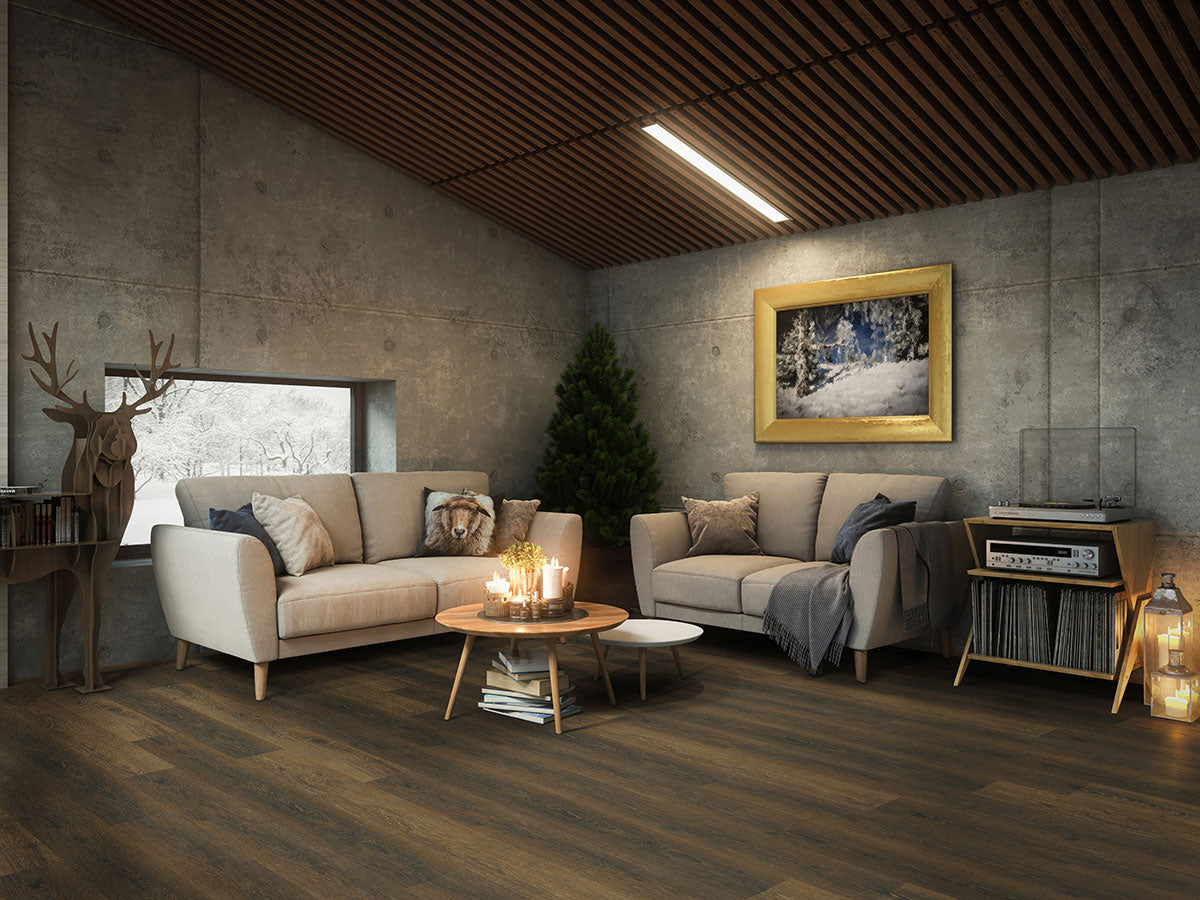 Modern cozy living room with concrete walls, MSI XL Cyrus Barrell Luxury Vinyl Planks flooring, beige sofas, a round coffee table with candles, Christmas tree, window, deer sculpture, record player, and a framed winter landscape painting.