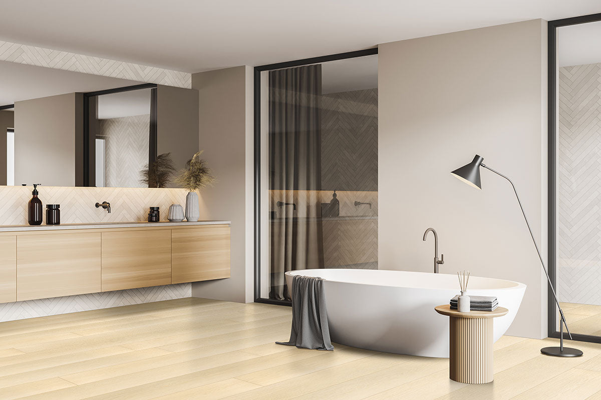 Modern bathroom with MSI XL Cyrus Lenexa Creek luxury vinyl plank floors (22.44 sq ft/box) featuring a durable CrystaLux™ wear layer, freestanding oval tub with gray towel, floor lamp, side table, and long vanity with large mirror and minimalist decor.