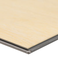 A close-up of the edge of an MSI XL Cyrus Lenexa Creek Luxury Vinyl Plank BOX (22.44 SQFT) showcases its layered build and interlocking tongue-and-groove beneath a durable CrystaLux™ wear layer.