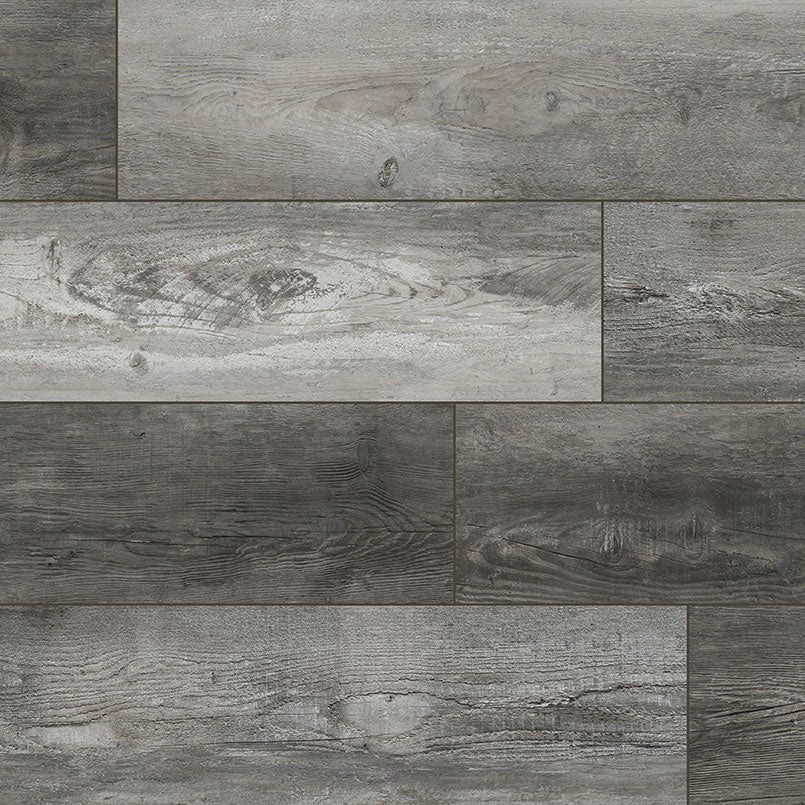 A close-up of MSI XL Cyrus Boswell Luxury Vinyl Planks BOX (22.44 SQFT) shows rectangular tiles in an offset pattern, displaying gray and brown wood-look tones with realistic grain and knot details for a weathered aesthetic.