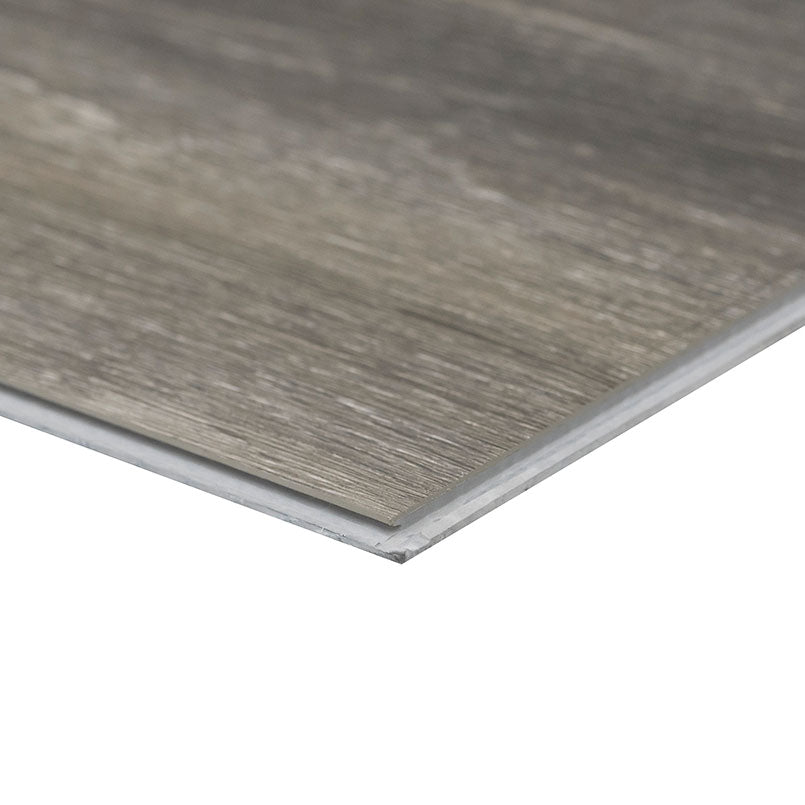 A close-up of an MSI XL Cyrus Bracken Hill Luxury Vinyl Plank highlights its thin profile, wood-like gray-brown texture, and CrystaLux™ protective finish for enhanced durability. Each box covers 22.44 sq ft.
