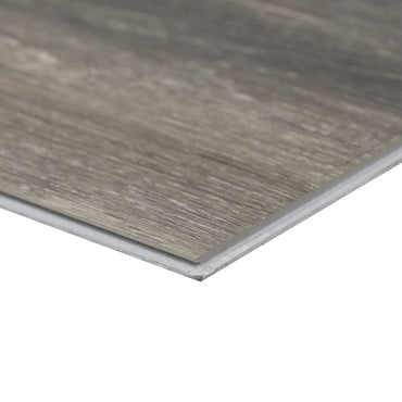 A close-up of an MSI XL Cyrus Bracken Hill Luxury Vinyl Plank highlights its thin profile, wood-like gray-brown texture, and CrystaLux™ protective finish for enhanced durability. Each box covers 22.44 sq ft.