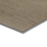 A close-up of an MSI XL Cyrus Cranton Luxury Vinyl Plank (22.44 sq ft) shows its thin, rectangular shape, wood grain texture, light brown color, layered edge detail, and 100% waterproof construction.