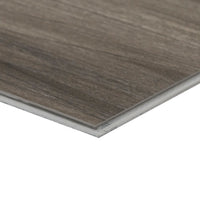 A close-up of the corner of an MSI XL Cyrus Jenta Luxury Vinyl Plank box (22.44 SQFT) shows its brown wood grain pattern and click-lock system, set against a white background.